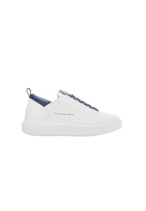 Sneaker bianca in pelle con accento blu navy sul tallone, caratterizzata da un marchio dorato, lacci rotondi e una suola bianca spessa.