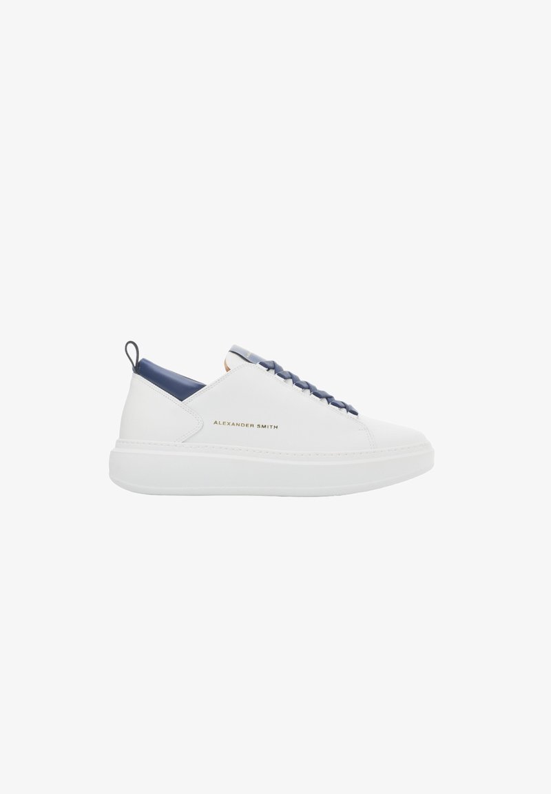 Sneaker bianca in pelle con accento blu navy sul tallone, caratterizzata da un marchio dorato, lacci rotondi e una suola bianca spessa.