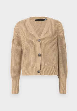 Beige knitted cardigan with a V-neck, oversized sleeves, and five buttons down the front. Features ribbed cuffs and a textured fabric.