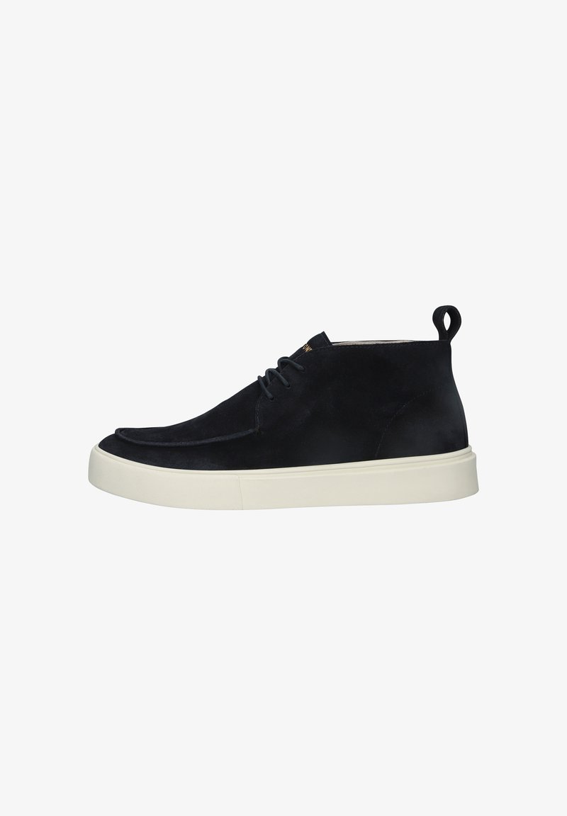 Botte de sport haute en daim noir avec une épaisse semelle en caoutchouc blanc et des lacets noirs, vue de côté sur un fond blanc.