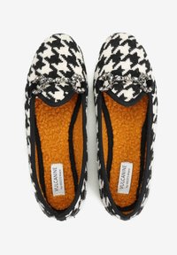 Czarno-białe kapcie w wzór houndstooth z pomarańczowym puszystym wykończeniem, czarnym obszyciem i dekoracyjnymi kryształowymi detalami na palcach.