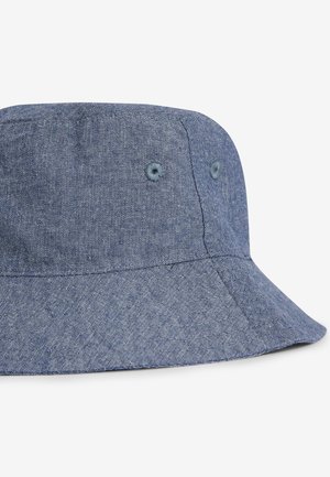 Zils džinsa bungu cepure ar mīkstu, teksturētu audumu, platu malu un diviem ventilācijas acu caurumiem sānos.