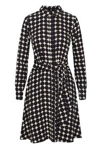 Robe à manches longues avec boutons, ornée de motifs circulaires noirs sur un fond crème, dotée d'une taille ceinturée et d'un col pointe.