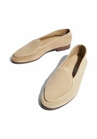 Mocasines de ante beige con punta redondeada y detalles cosidos, con un tacón bajo y un forro interior suave para mayor comodidad.