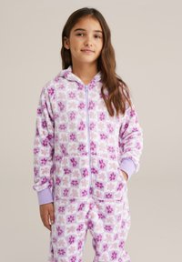 Puha lila overall virágmintával, elöl cipzárral, kapucnival és zsebekkel. Lágy tapintású anyag, világos lila bordázott mandzsettákkal.
