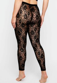Zwarte kant leggings met een bloemenpatroon, semi-transparante textuur en een elastische tailleband. Aansluitend ontwerp met een enkel-lange snit.