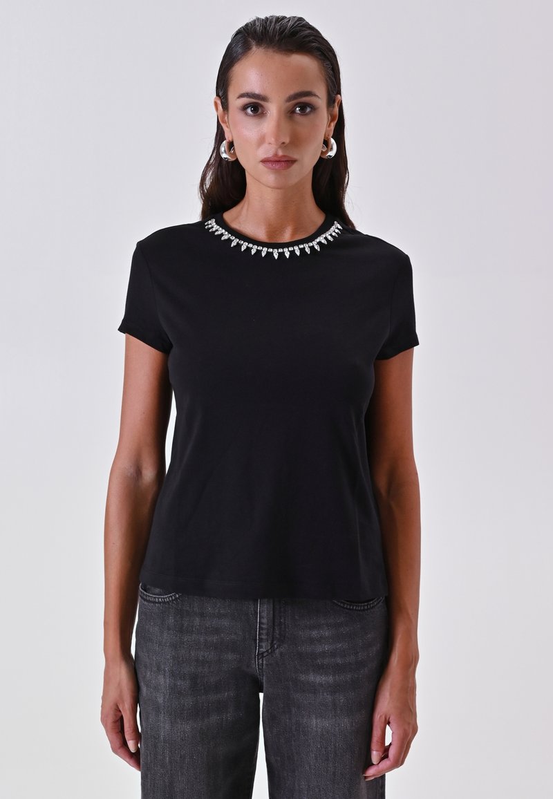 T-shirt nera a maniche corte con un colletto decorativo in strass. Tessuto morbido con una vestibilità comoda e design semplice. Abbinato a jeans scuri.