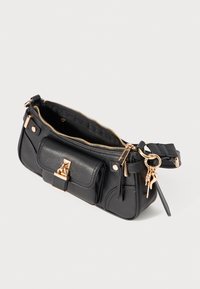 Sac à main en cuir noir avec une finition texturée, des accessoires en or, une fermeture éclair et une poche avant. Il est doté d'une bandoulière amovible et d'un porte-clés.
