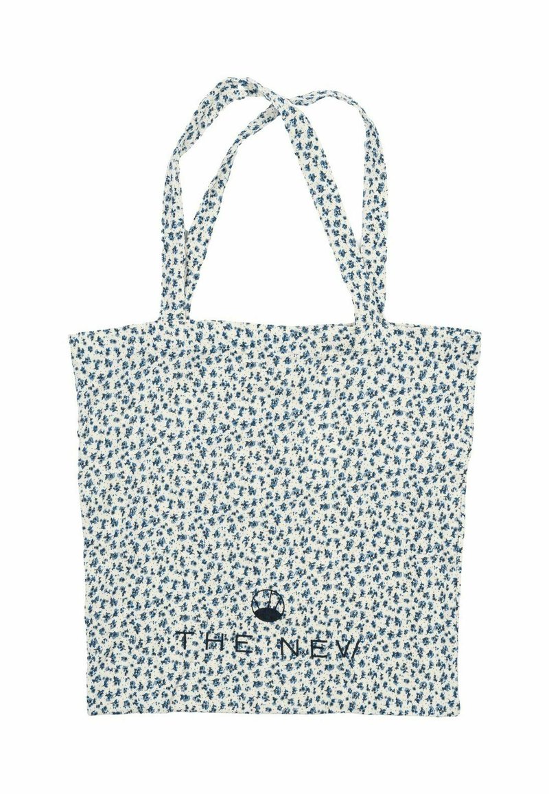 Vit tygkasse med blå blommönster, två långa remmar och texten "THE NEW" broderad i nederkant på mitten.