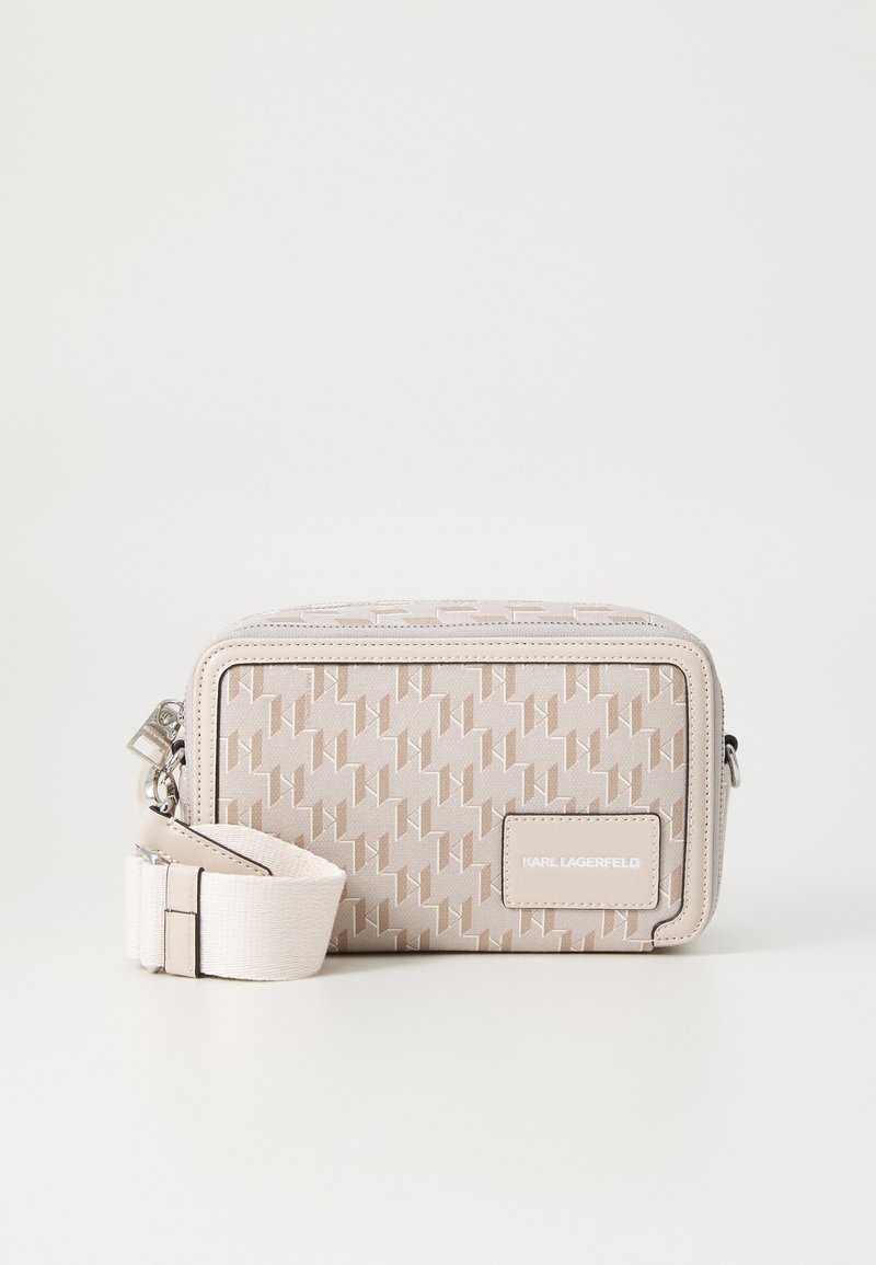Sac bandoulière beige à motifs de forme rectangulaire, finition texturée, quincaillerie en argent et une bandoulière amovible avec une boucle réglable.