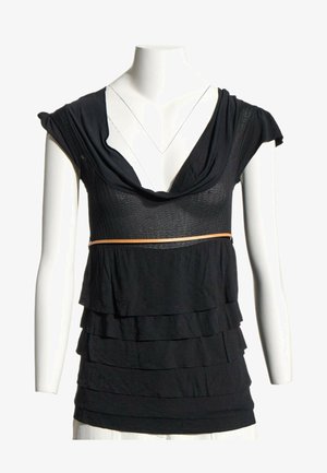 Blouse noire sans manches à couches avec un large col et une fine ceinture beige, présentée sur un mannequin torse blanc avec des manches courtes.