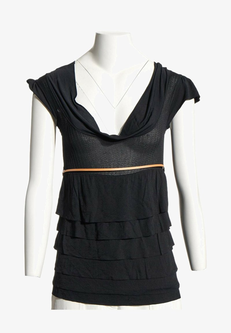 Blouse noire sans manches à couches avec un large col et une fine ceinture beige, présentée sur un mannequin torse blanc avec des manches courtes.