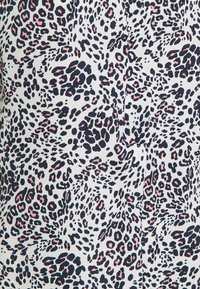 Tela con base blanca que presenta un estampado abstracto de leopardo en tonos azul marino, rosa y negro. Textura suave con tamaños y formas de manchas variadas.
