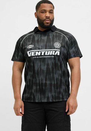Jersey negro con un patrón texturizado y ondulado, mangas cortas y un collar. Logo "VENTURA" en blanco en el frente.