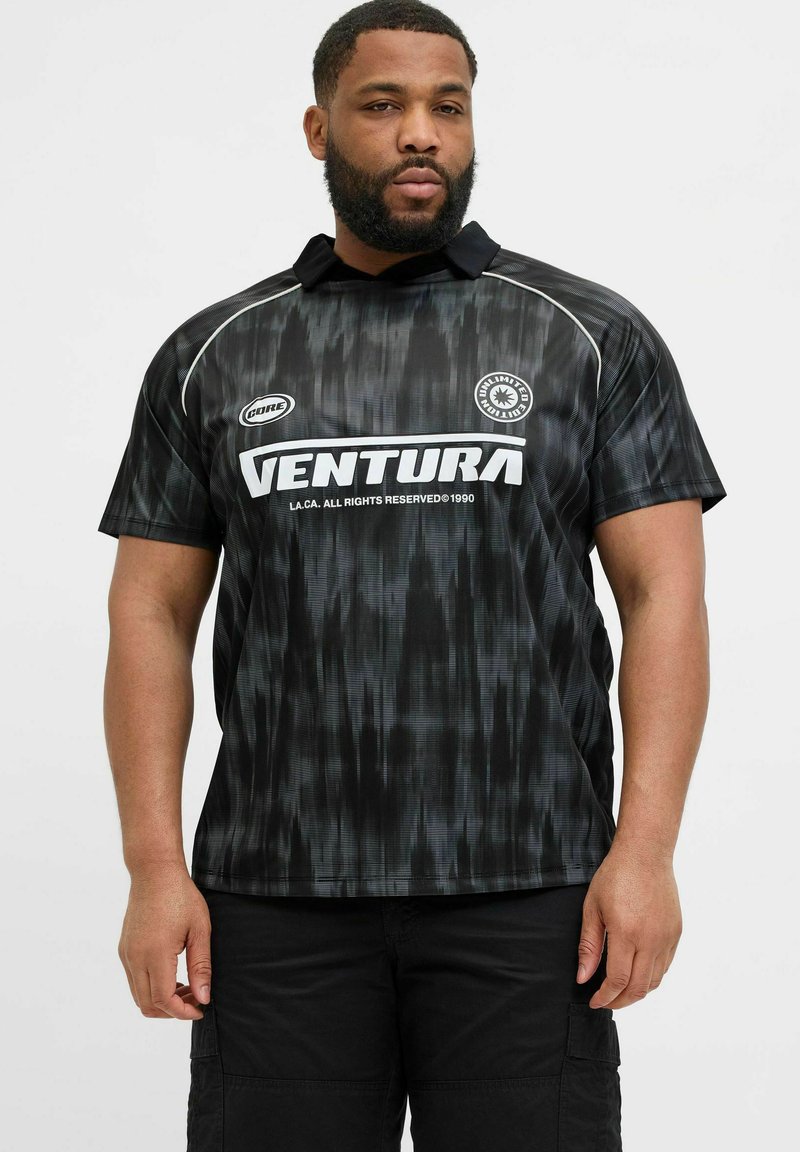 Jersey negro con un patrón texturizado y ondulado, mangas cortas y un collar. Logo "VENTURA" en blanco en el frente.