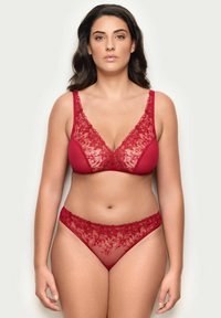 Czerwony koronkowy biustonosz i dopasowany stringi, zdobione kwiatowymi wzorami, przezroczystymi panelami i falbaniastymi krawędziami. Miękka tekstura, dekolt w serek, szerokie ramiączka.