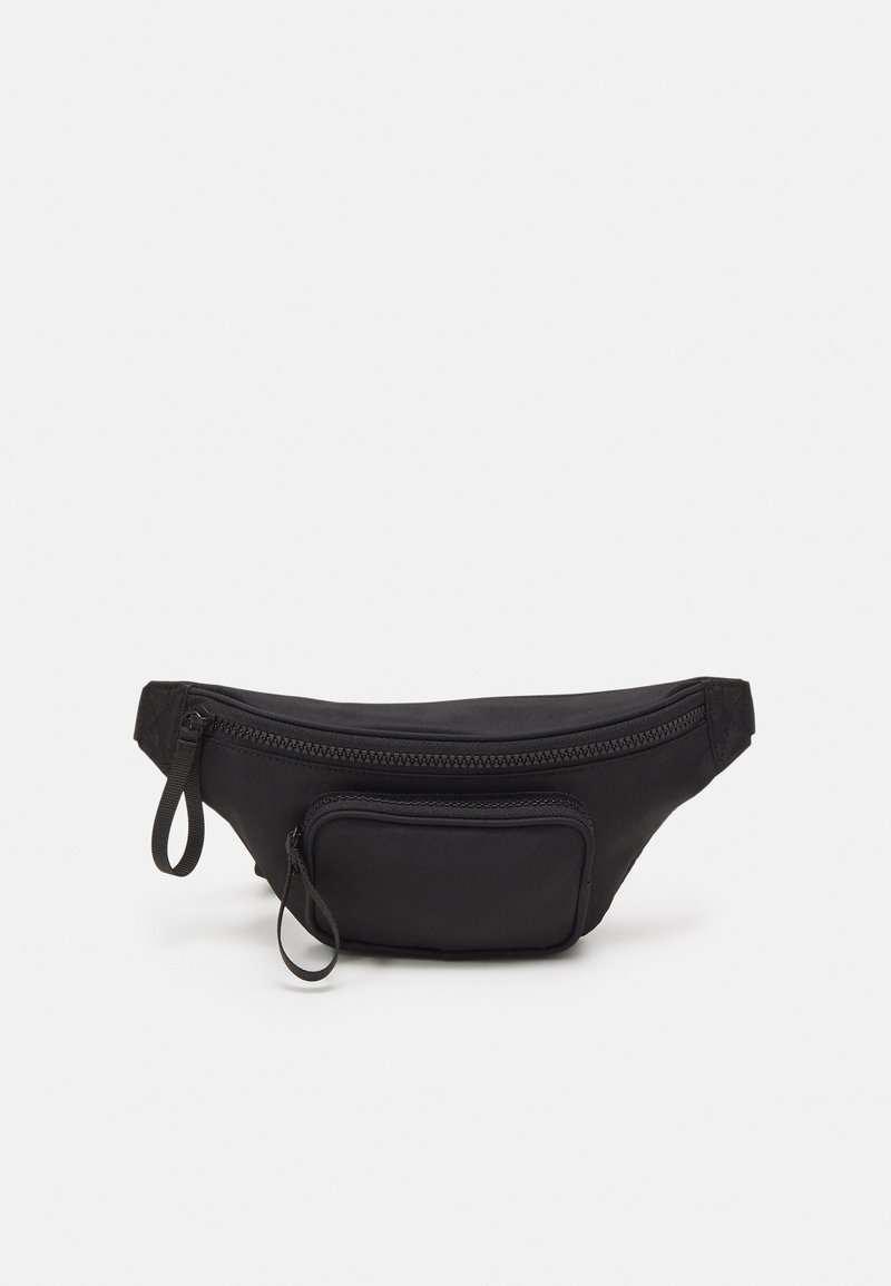 Fanny pack en tissu noir de forme arrondie, avec un compartiment principal zippé et une petite poche avant zippée. Finition texturée.