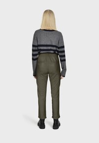 Pull gris à rayures avec des lignes navy, associé à un pantalon taille élastique vert olive, et des bottines noires. Vue arrière.