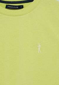 Ljusgrön sweatshirt i bomull med rund halsringning och en liten vit golfare-grafik på vänster sida.