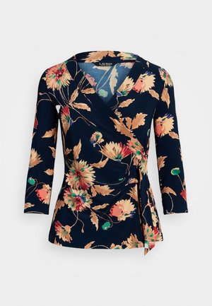 Top envolvente en tela azul marino con grandes estampados florales en tonos melocotón, verde y rojo. Mangas tres cuartos con detalle fruncido en el lateral.
