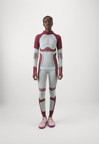 Bordó és világosszürke sportos ruházati szett. Fittel hosszúujjú felső függőleges paneles díszítéssel, hozzáillő leggings színkiegészítőkkel. Könnyű anyagból készült.