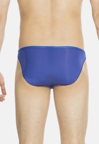Blue men's swim briefs made of stretchy material, featuring a low-rise design and smooth texture, with minimal seams and a clean finish.