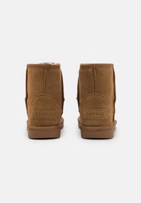 Paire de bottines en daim marron avec doublure en fourrure, semelles en caoutchouc plates, et logo "ESPRIT" embossé à l'arrière du talon.