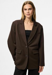 Rjav oversized blazer z izrezanim ovratnikom, dvema sprednjima žepoma in enojnim gumbom za zapiranje. Gladka tkanina z strukturirano obliko.