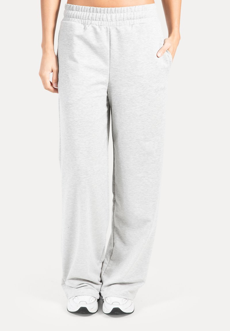 Pantalones deportivos grises con cintura elástica, corte suelto, bolsillos laterales y textura suave. Presentan una marca sutil en el muslo.