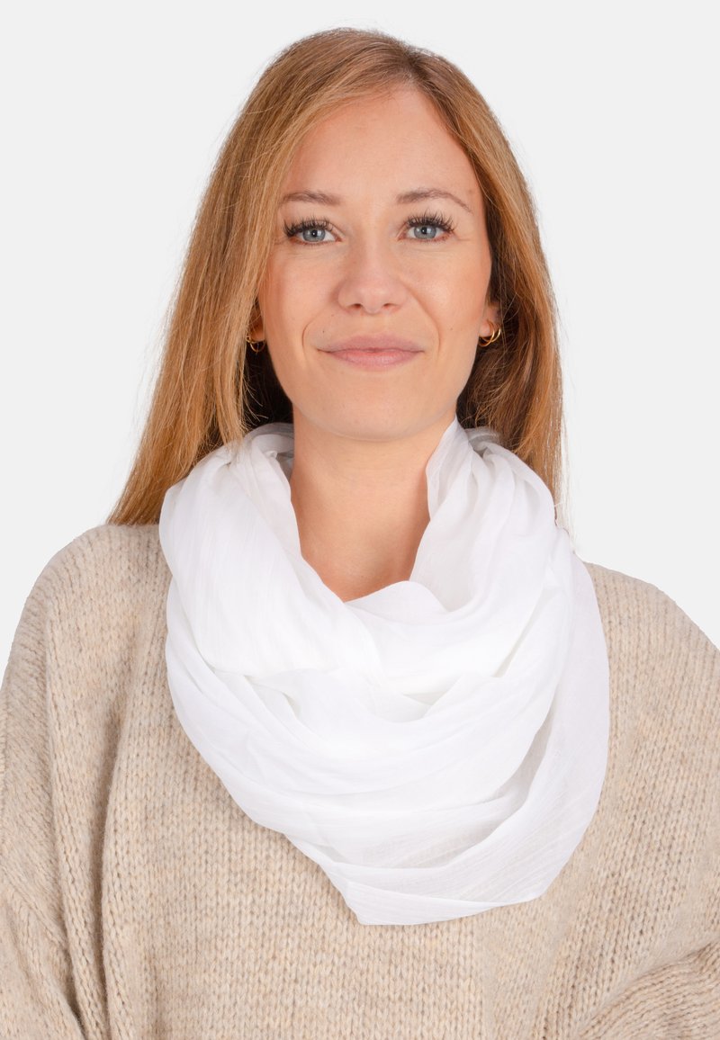 Écharpe blanche, légère, en plusieurs couches, faite d'un tissu doux et transparent. Elle est drapée autour du cou, mettant en valeur une texture lisse et un design fluide.