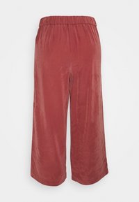 Culottes en velours côtelé rouge avec une coupe large, une taille élastique et une texture lisse. Présente une coupe décontractée et des bords ourlés pour un enfilage facile.