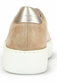 Sneaker mit beigem Wildlederschaft, silberner metallic Ferseneinsatz, weißer Gummisohle und kontrastierenden Nähten auf der Rückseite.