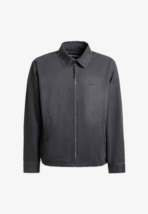 Mørkegrå jakke med glidelås, krage og sidelommer, med subtilt merkevarelogo på brystet.