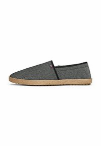 Grå kanvas slip-on sko med spidse tæer, sorte stofdetaljer og en vævet jute-sål. Har et lille logo-tag på siden.