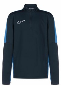 Laivastonsininen puolivetoketjullinen collegepaita pitkillä hihoilla, jossa on siniset korostuspaneelit sivuilla, teksturoitu kangas ja valkoinen Nike-logo rinnassa.