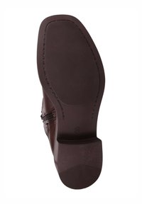 Suela de bota de cuero marrón con superficie texturizada, punta redondeada y tacón bajo. Detalle de cremallera lateral y tamaño marcado 36.