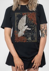 Black cotton t-shirt featuring a graphic of a white bird surrounded by red floral patterns and the text "Fleetwood Mac" in an ornate style.