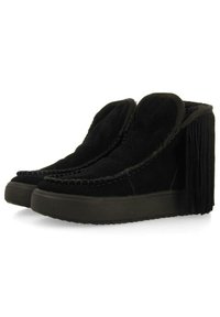 Botas de tobillo de ante negro con una parte trasera con flecos, punta redondeada y costuras en contraste. Suela gruesa y texturizada para mayor altura y agarre.