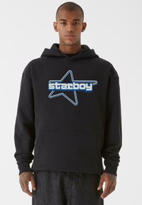 Fekete kapucnis felső nagy kék csillag logóval és világoskék "starboy" felirattal. Elöl zseb található, valamint bordázott mandzsetták. Pamut keverék anyag.