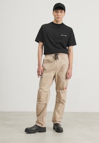 HUGO GARLO - Oldalzsebes nadrágok - medium beige