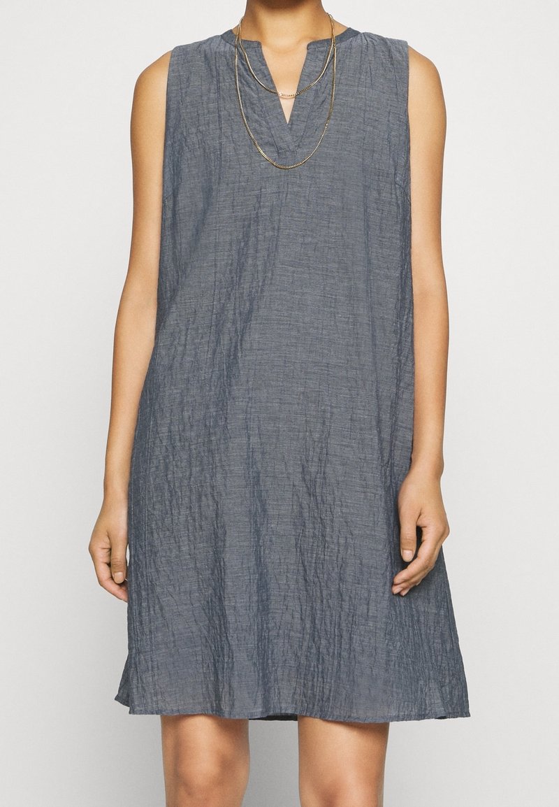 Robe sans manches, longueur genou, en tissu bleu foncé texturé avec un décolleté en V. Elle présente une coupe ample et un motif froissé subtil.