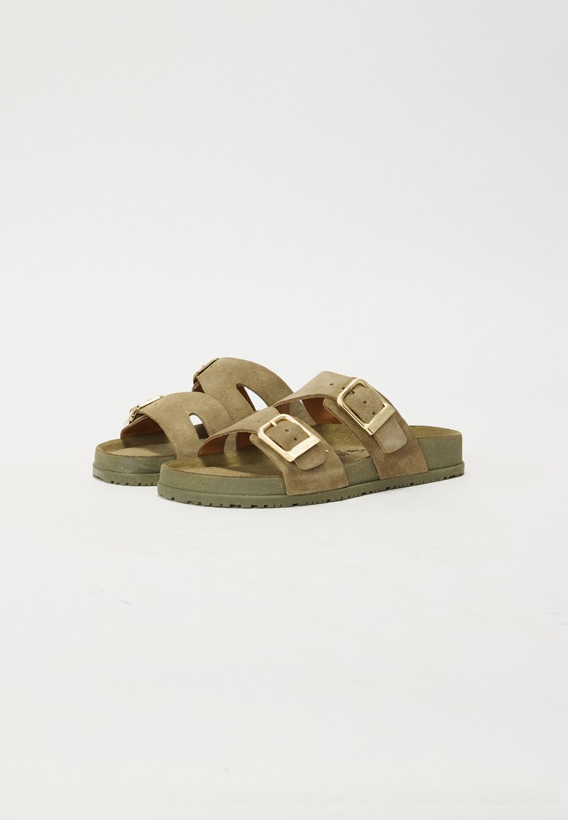 Bruna slidesandaler med två justerbara remmar och guldspännen, placerade mot en vit bakgrund. Perfekta för vardagligt bruk.