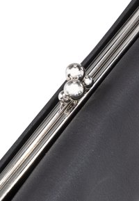 Zwarte clutch met een gladleren buitenkant, voorzien van een zilveren sluiting versierd met drie bolvormige accenten.