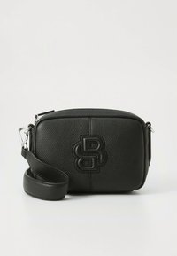 Fekete bőrből készült keresztpántos táska, texturált felülettel, az elején kiemelt logóval és levehető pánttal. Téglalap alakú.