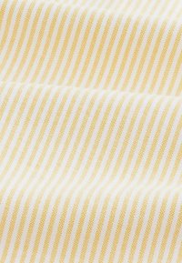 Cotton fabric featuring alternating yellow and white stripes. The texture is smooth with a tight weave, showcasing a consistent pattern.