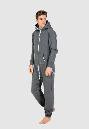 Grijze fleece onesie met een rits aan de voorkant, capuchon en witte koord. Beschikt over twee zijzakken en een klein logo aan de voorkant. Smeuïge textuur.