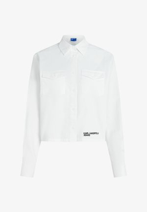 Bijela kratka košulja s dugim rukavima s gumbima sprijeda, dva džepa na prsima s gumbima, šiljasti ovratnik i logo "KARL LAGERFELD JEANS" blizu ruba.