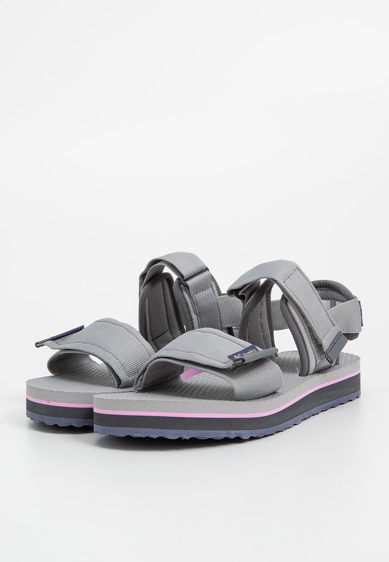 Ein Paar graue Sandalen mit verstellbaren Riemen und gepolsterten Sohlen, die pink und schwarz gestreifte Zwischensohlen und strukturierte Fußbetten aufweisen.