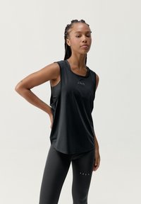 Czarny bezrękawnik sportowy z zaokrąglonym dołem, z subtelnym logo na klatce piersiowej i siateczkowymi panelami zapewniającymi wentylację.