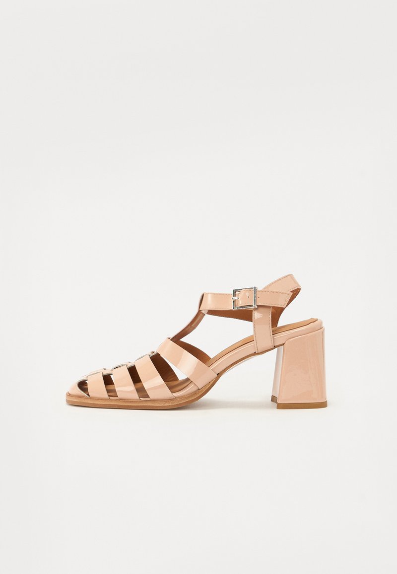 Beige patendi nahkste sandaalid, millel on rihmadega disain, avatud varbad, pandla detail ja plokk konts. Sujuv tekstuur ja läikiv viimistlus.